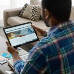 Seorang profesional menggunakan tablet untuk mengakses LinkedIn dan melakukan aktivitas outreach sebagai LinkedIn Outreach Specialist