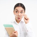 Potret wanita Asia berkacamata berpakaian formal membaca rekomendasi buku untuk pencari kerja