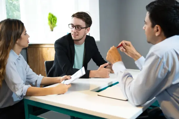 tiga orang yang sedang berdiskusi sedang mewawawancarai fresh graduate cara menjawab interview