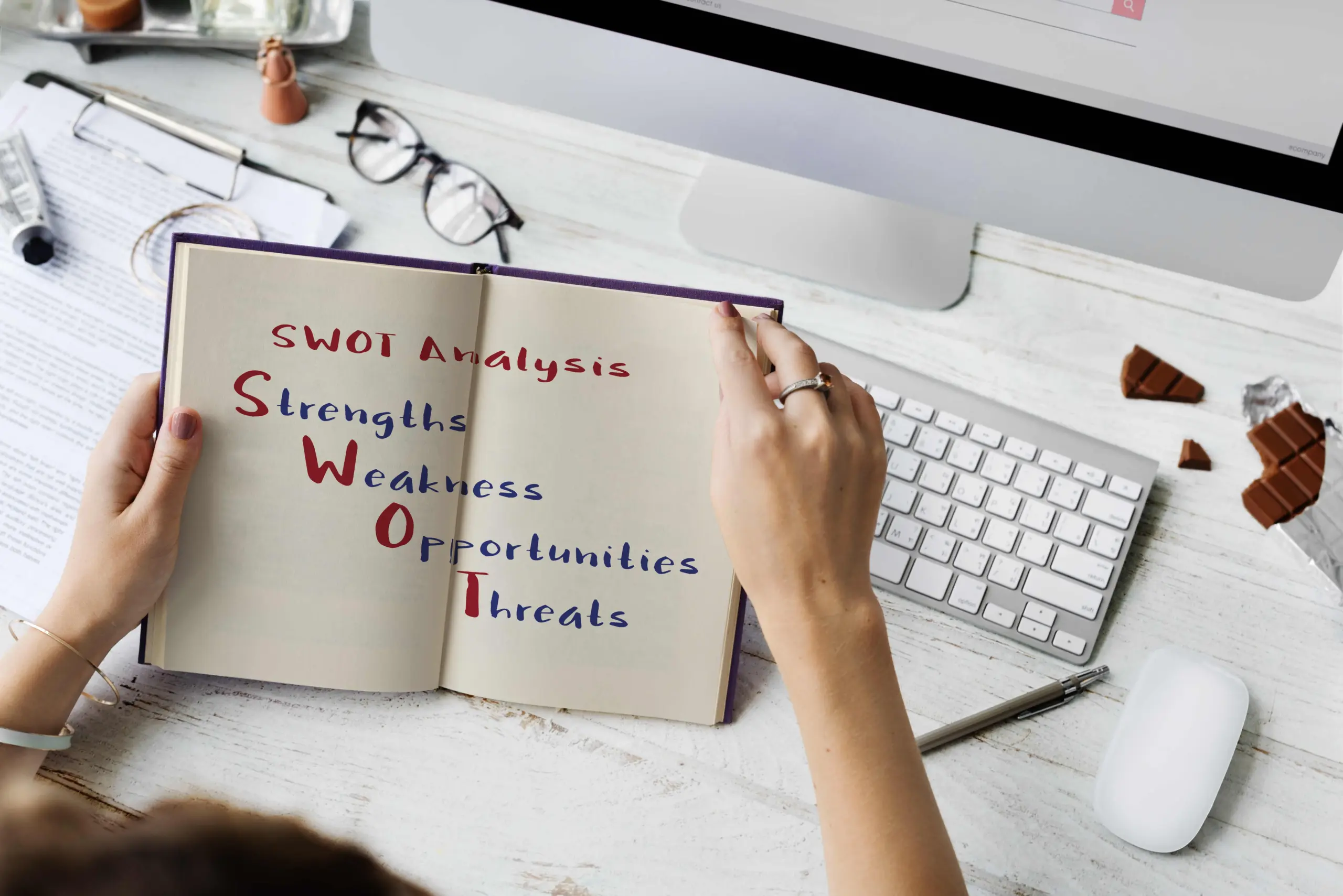 Contoh ilustrasi analisis SWOT di buku berwarna coklat yang dibuat oleh fresh graduate.